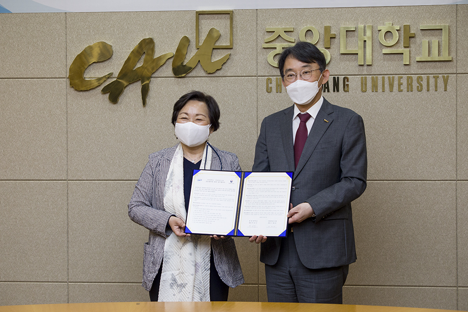 서혜란 관장과 박상규 총장이 서명한 협약서를 나눠들고 기념촬영하고 있다.