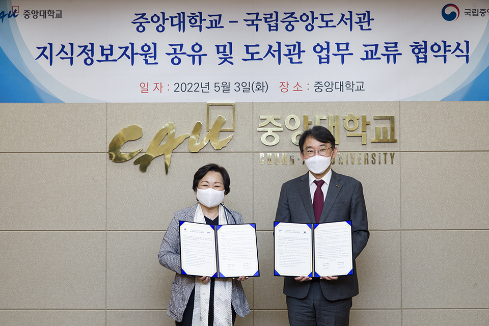 서혜란 관장과 박상규 총장이 서명한 협약서를 들고 기념촬영하고 있다.
